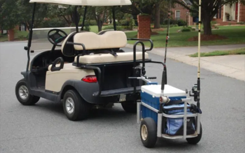 Golf cart accessories featuring a cooler trailer and fishing rod holders, showing how golf carts can be customized for fishing and outdoor activities.